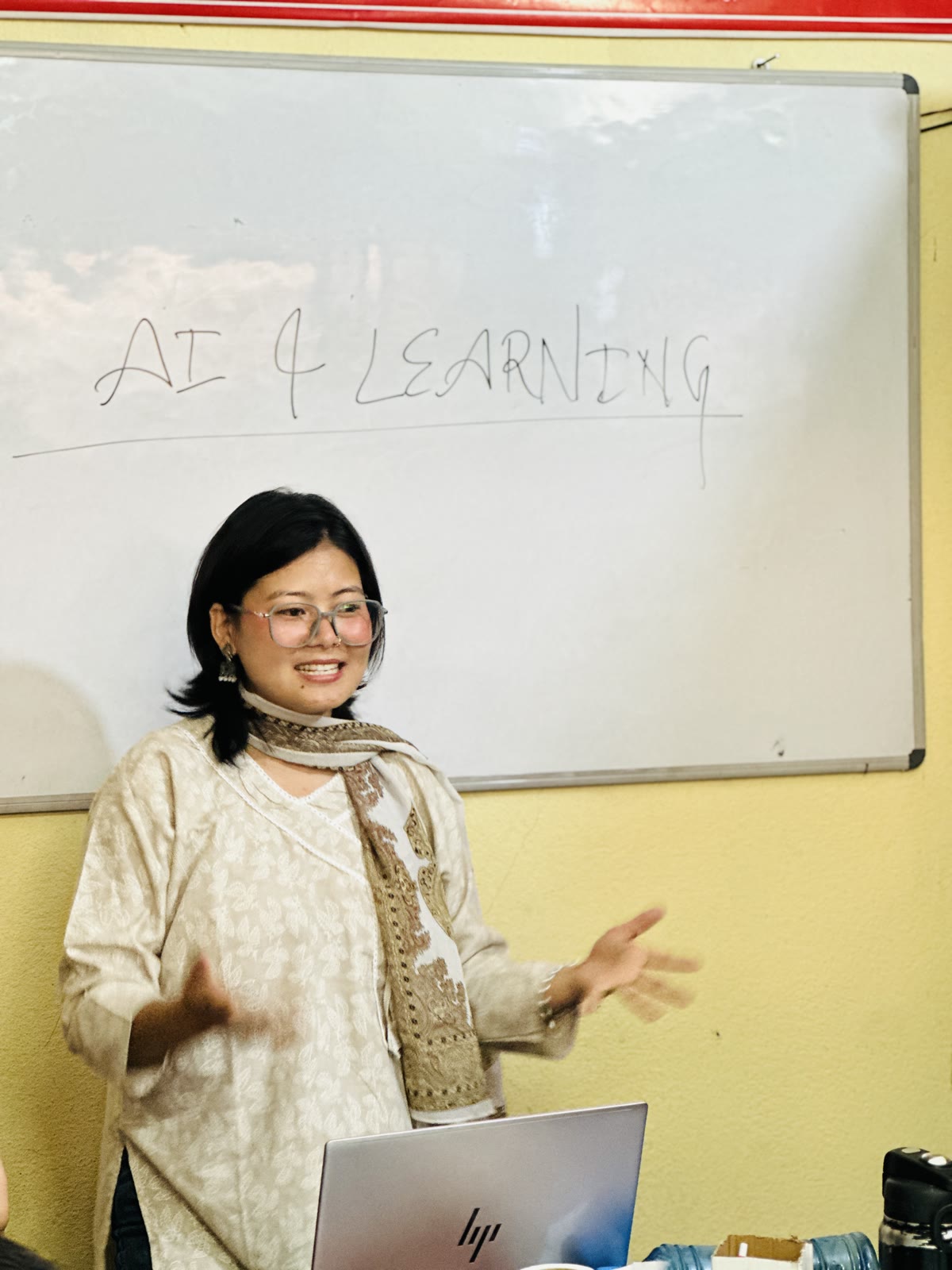 Dipa leading a JUST AI session in front of the AI & Learning whiteboard
