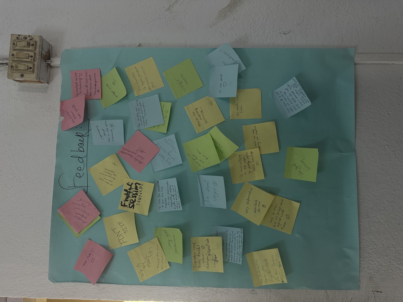 A feedback board covered in colourful sticky notes written by participants after the session